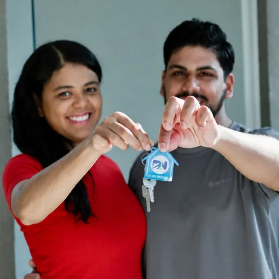 Casal segurando a chave do primeiro imóvel